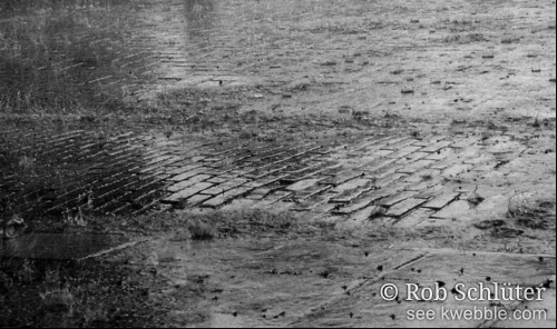Hevige regen spat op in de plassen op straat.