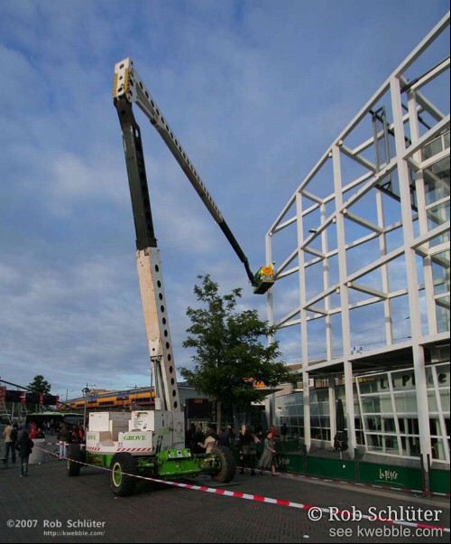 Hoogwerker in gebruik om het geraamte van station Leiden schoon te maken.
