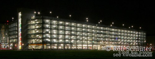 In het donker straalt de verlichting uit een grote glazen garage.